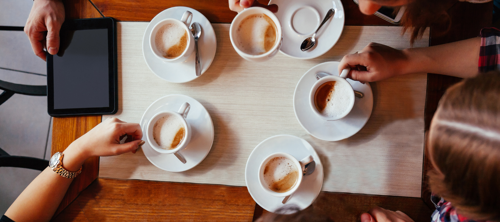 Five people sitting with their drinks at a cafe