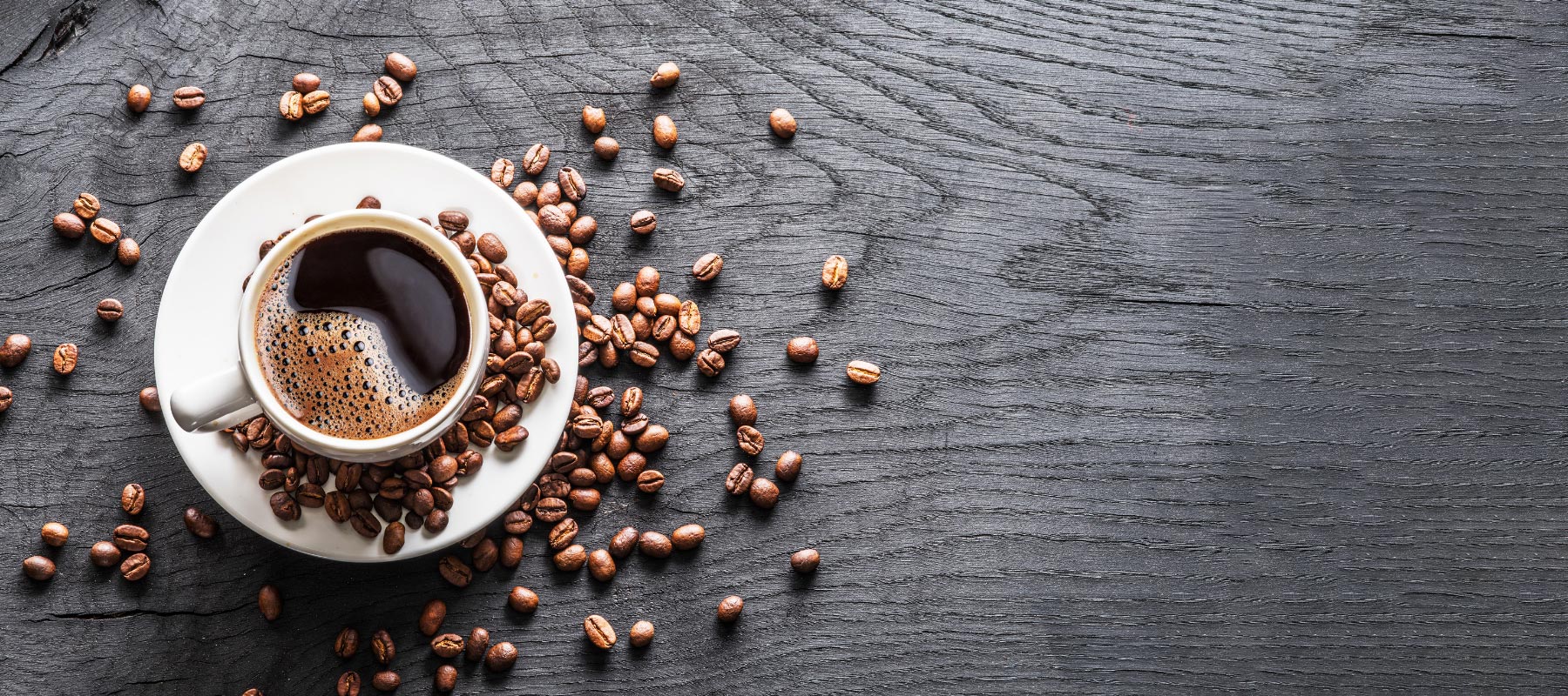 Coffee and espresso beans against a grey background.