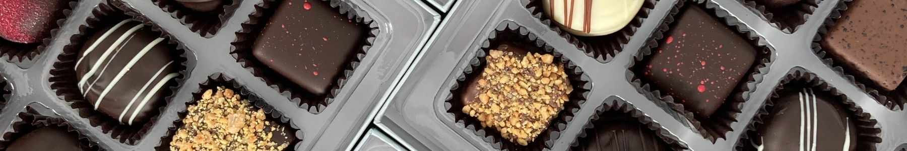 Dilettante Chocolates CHocolate Truffles inside a beautiful silver gift box featuring raspberry, l'orange, and praline truffles