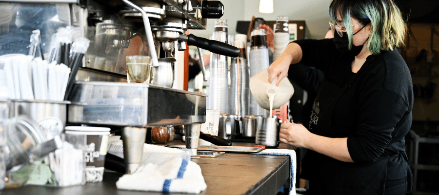 Dilettante Mocha Café Barista preparing a coffee drink with milk